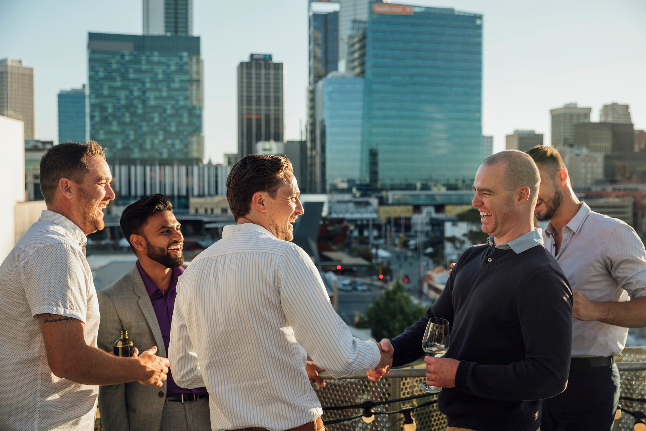 Professionals networking and greeting on a rooftop