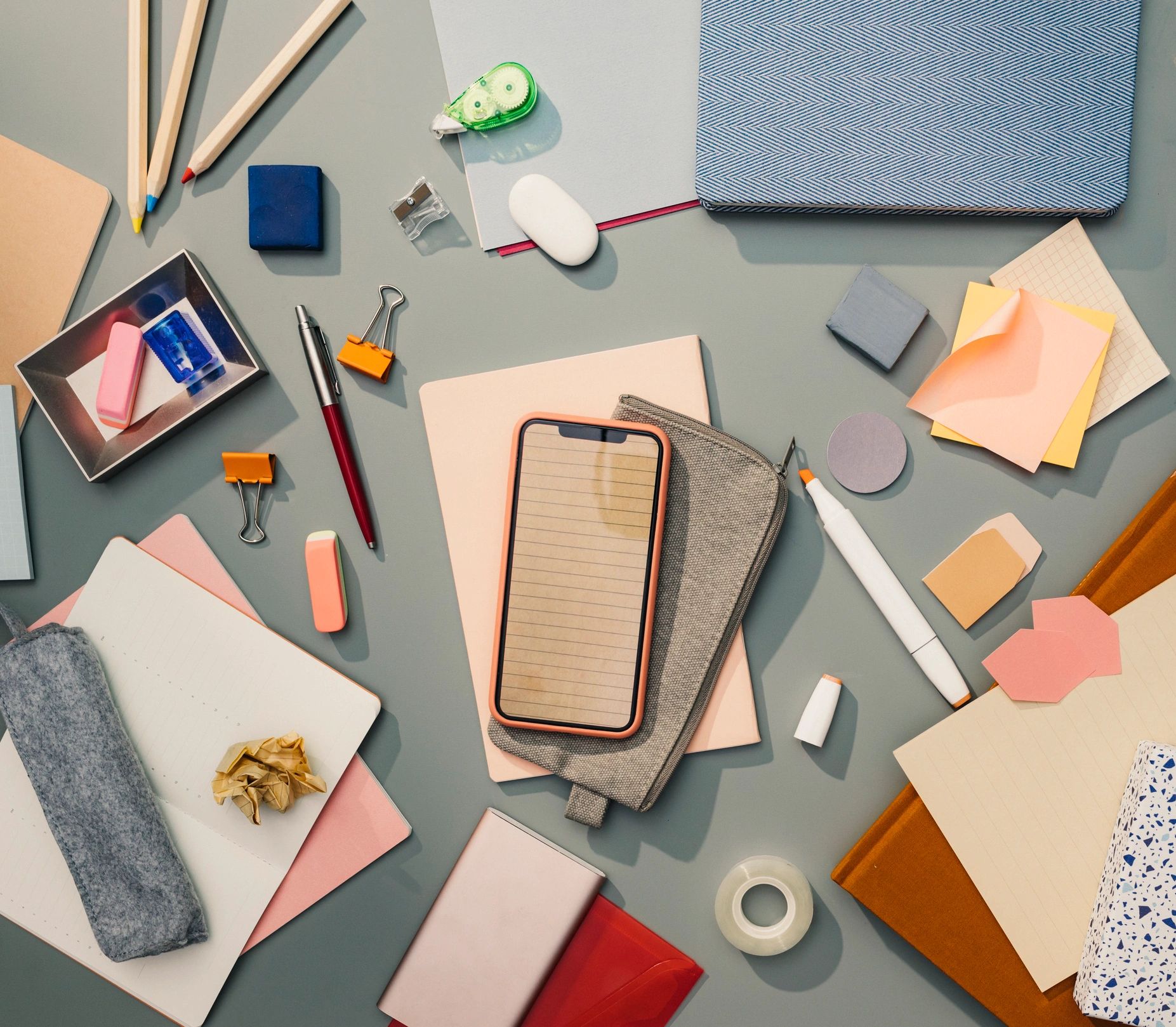 Flat lay of office supplies including notebooks and pens