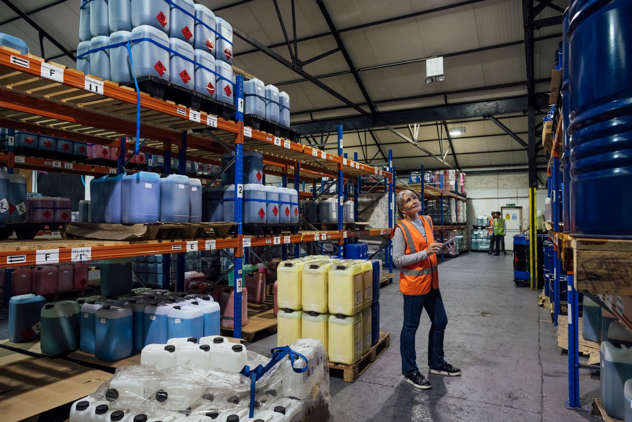 Worker checking inventory with a tablet in a warehouse setting