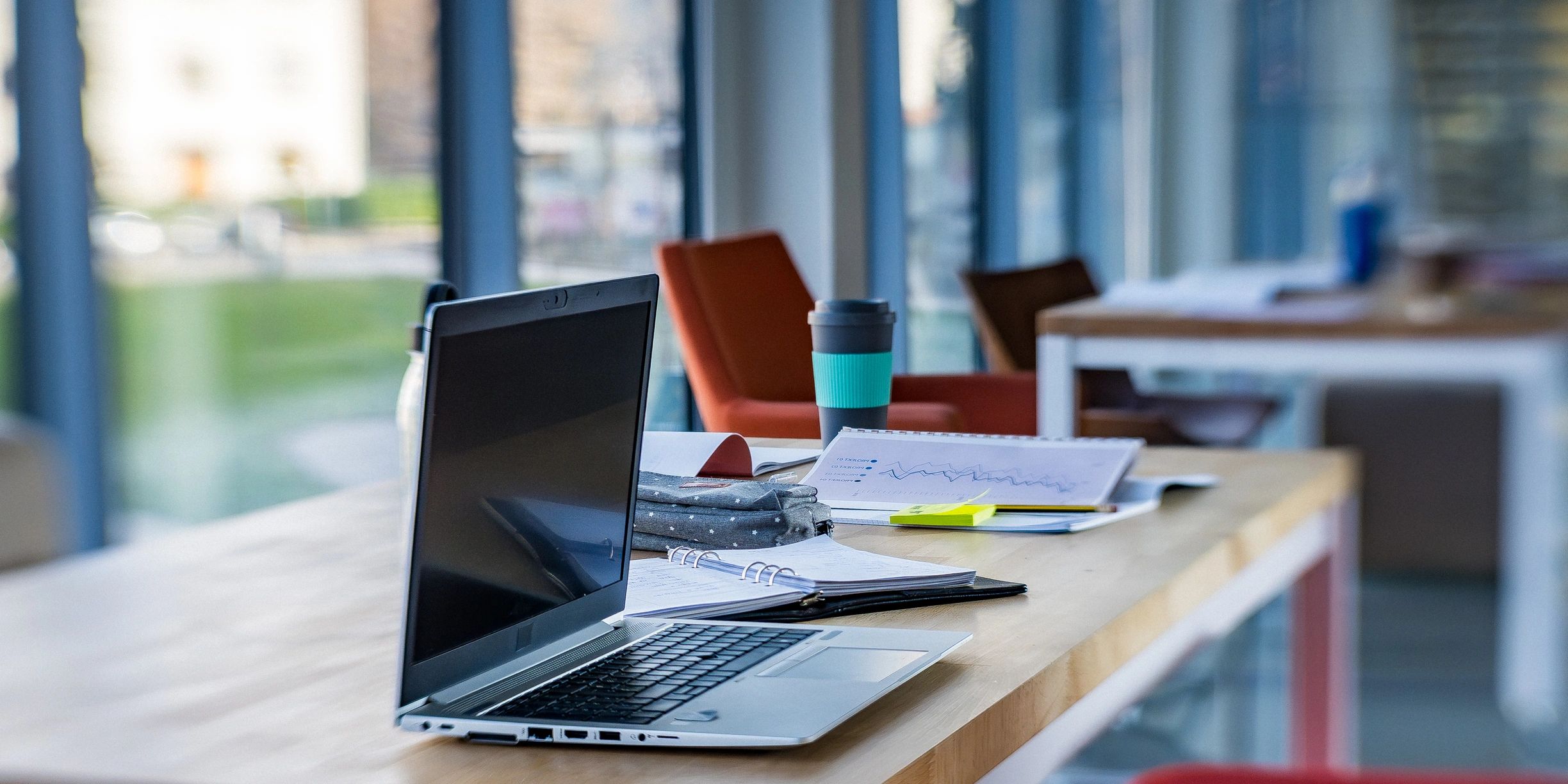 Modern office workspace with laptop and notebook